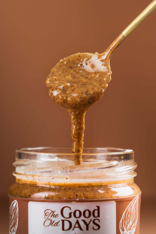 Amlou, 100% natural Berber spread with almonds, argan oil, and acacia honey, in a jar with a golden spoon.