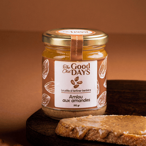 Amlou aux amandes in a jar on a wooden board with bread and almonds, a natural Berber spread.