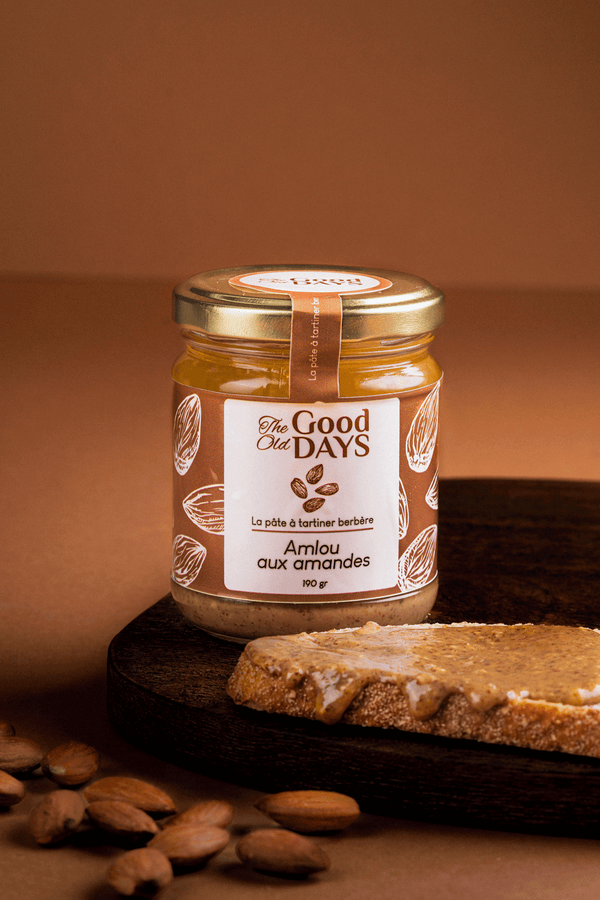 Amlou aux amandes in a jar on a wooden board with bread and almonds, a natural Berber spread.