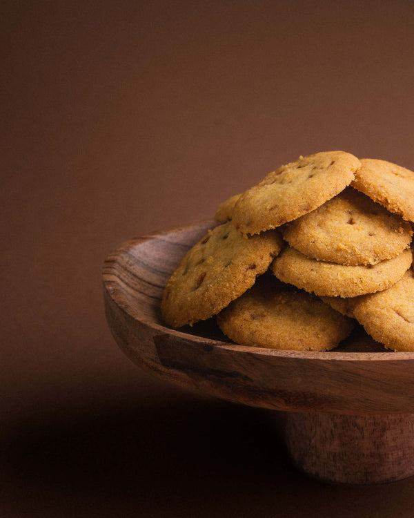 Palets au caramel beurre salé dans une assiette en bois sur fond brun