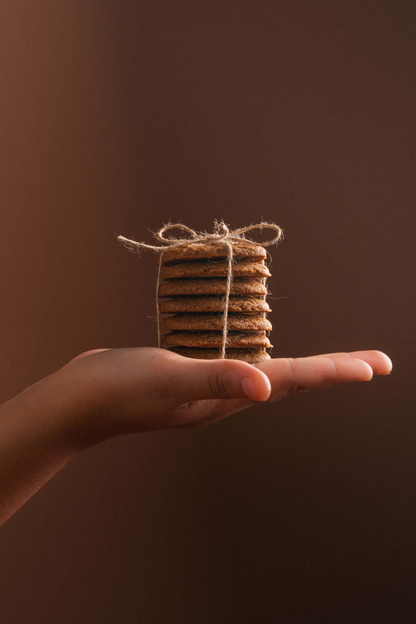 Spéculoos attachés avec une ficelle dans une main, présentation cadeau